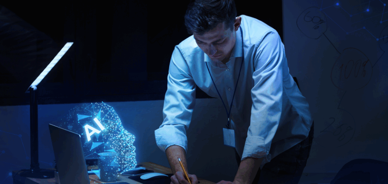 Hombre trabajando junto a una laptop con proyección de un rostro digital con las siglas "AI", simbolizando el uso de inteligencia artificial en el testing de software.