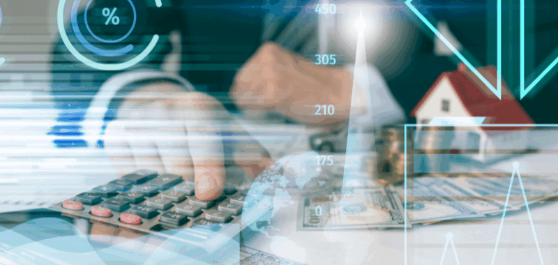 Ejecutivo financiero usando calculadora con gráficos, billetes y casa en miniatura, representando el uso de tecnología para gestionar riesgos operacionales.