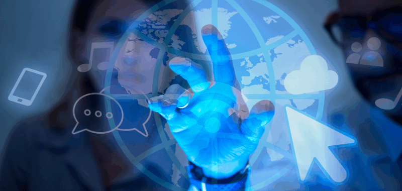 Personas interactuando con una interfaz digital transparente que muestra iconos de nube, comunicación, música y un globo terráqueo, simbolizando la conectividad, la transformación digital y el uso de tecnologías avanzadas.
