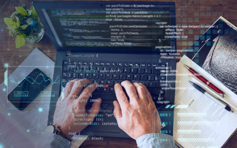 Persona trabajando en un portátil mientras analiza código y datos, representando prácticas modernas de testing, automatización inteligente y aseguramiento de calidad en entornos críticos.